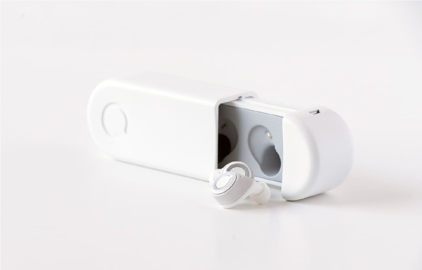 Cue wireless headphones next to charging box
