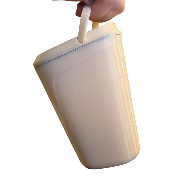 A hand holding a light beige, rectangular plastic container with a handle and a…