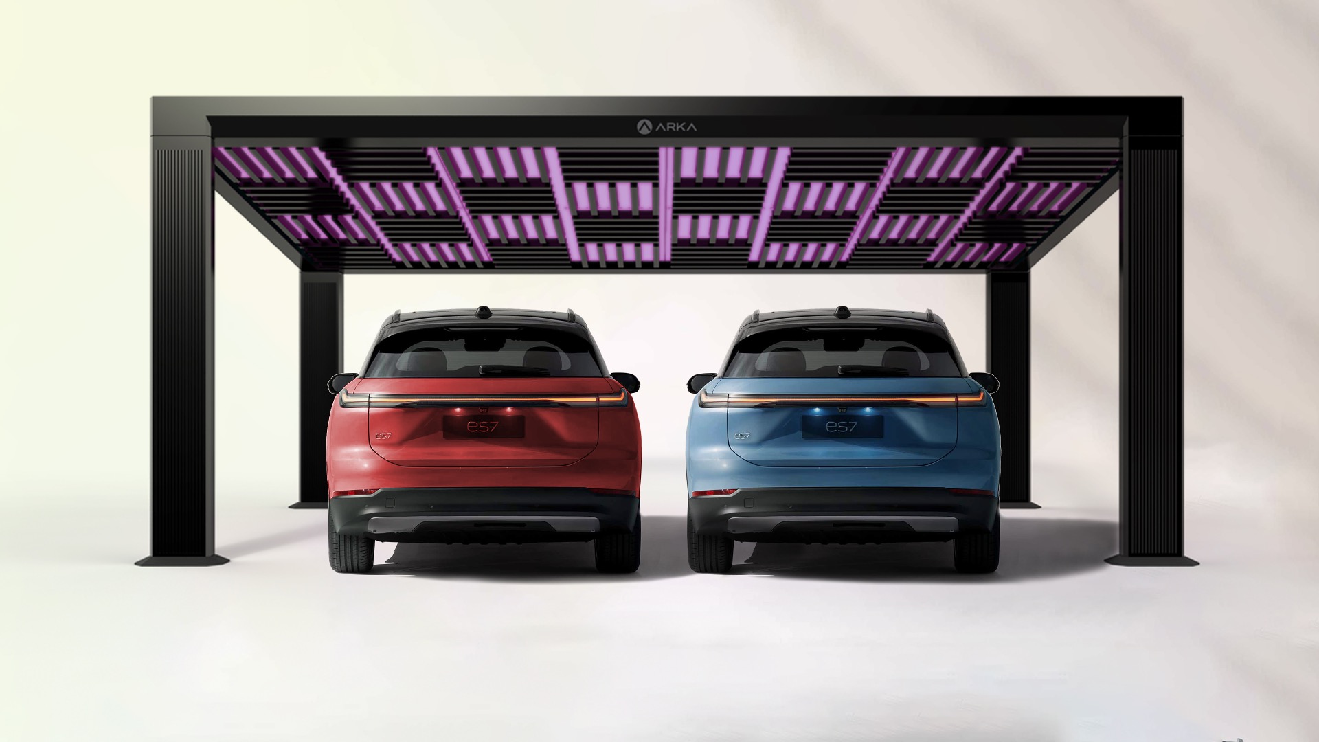 Two electric SUVs, one red and one blue, are parked side by side under a modern