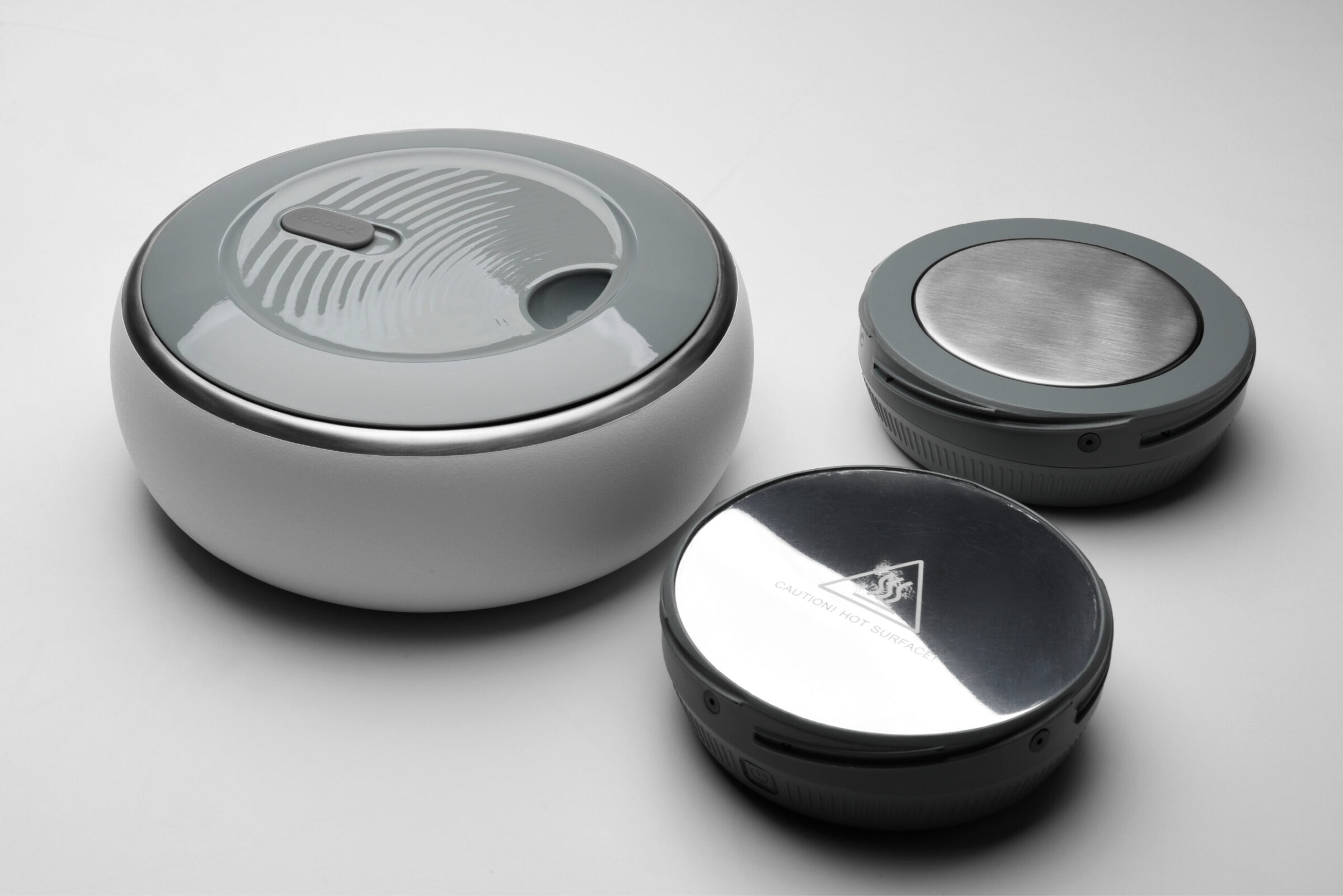 Three round, modern electronic devices with metallic and plastic surfaces are placed…