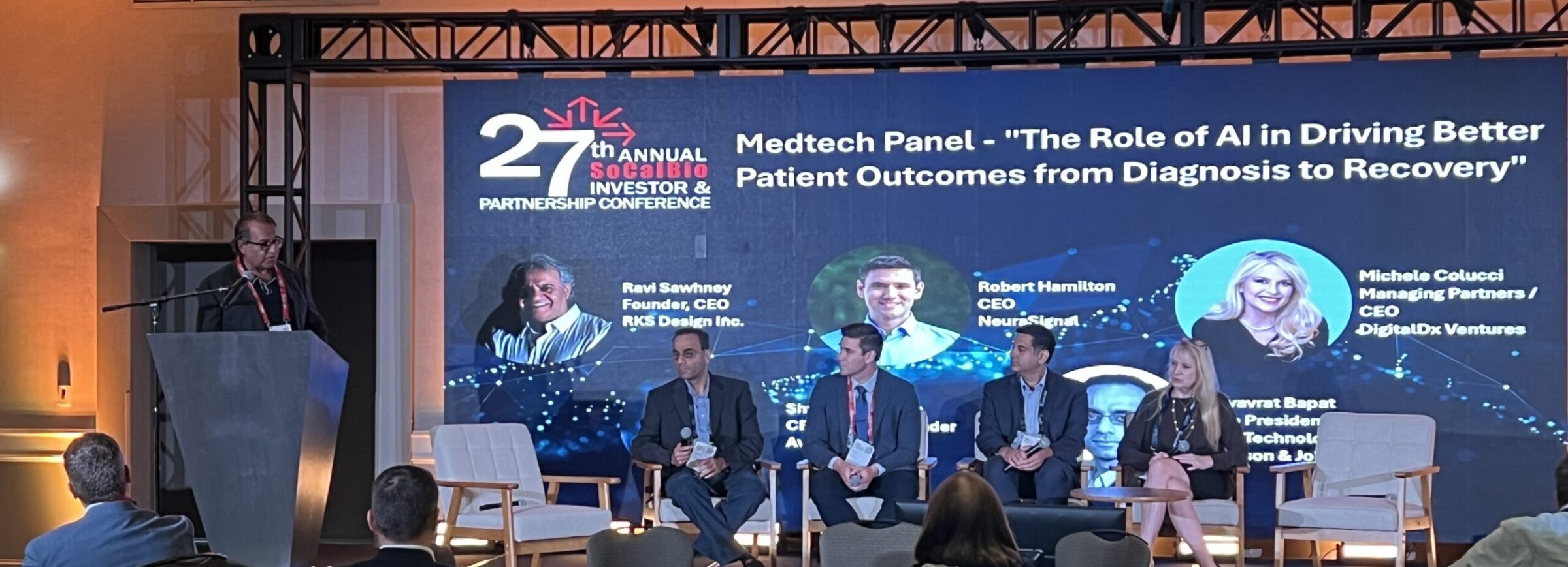A panel of five speakers sits onstage at the 27th SoCalBio Investor & Partnership…