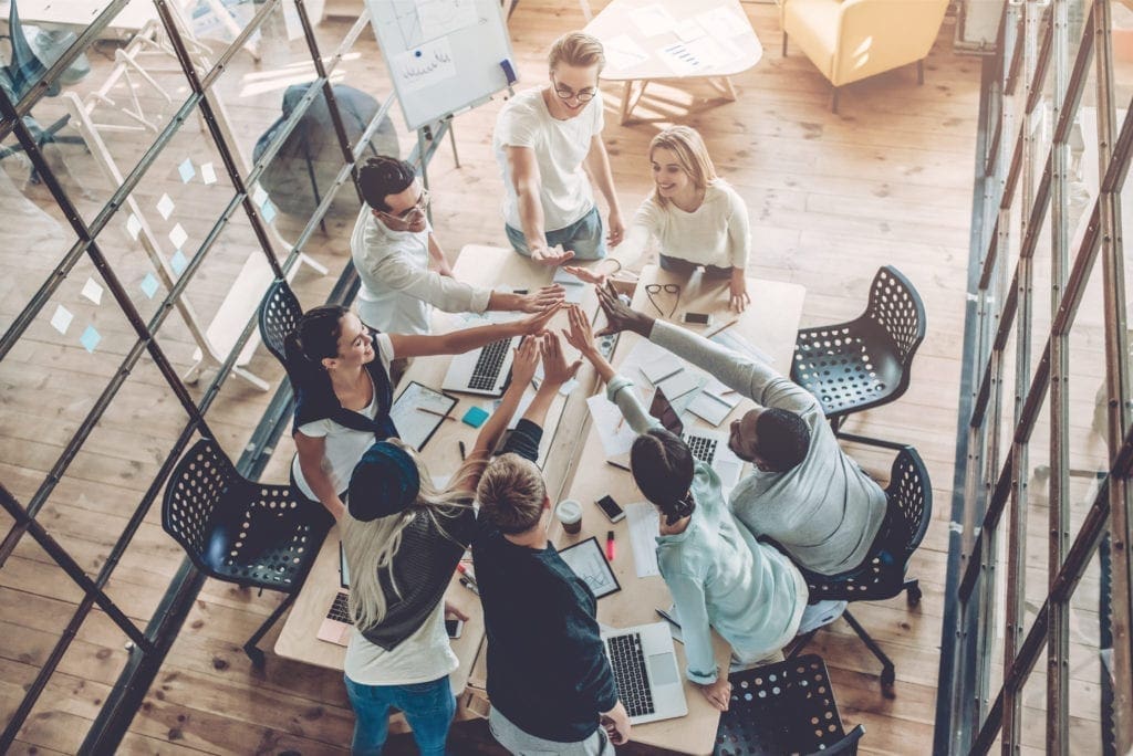 People working at desk high-fiving
