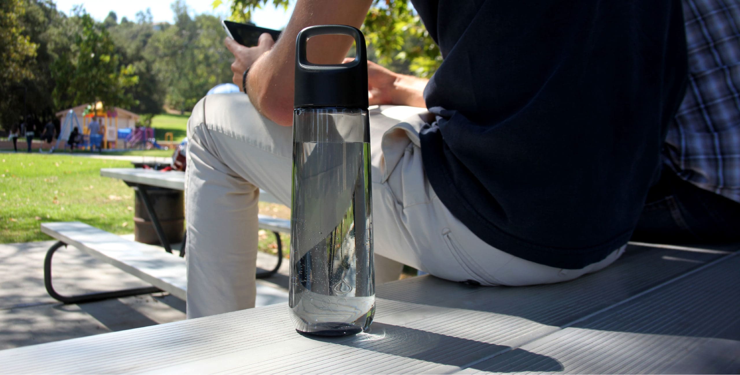 Person sitting next to kor water bottle