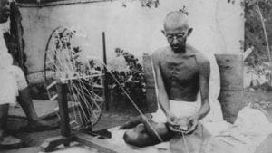 Mahatma Ghandi working at spinning wheel