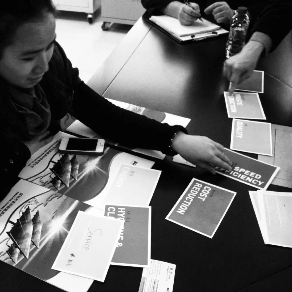 Participant organizing printed cards during a product concept feedback exercise