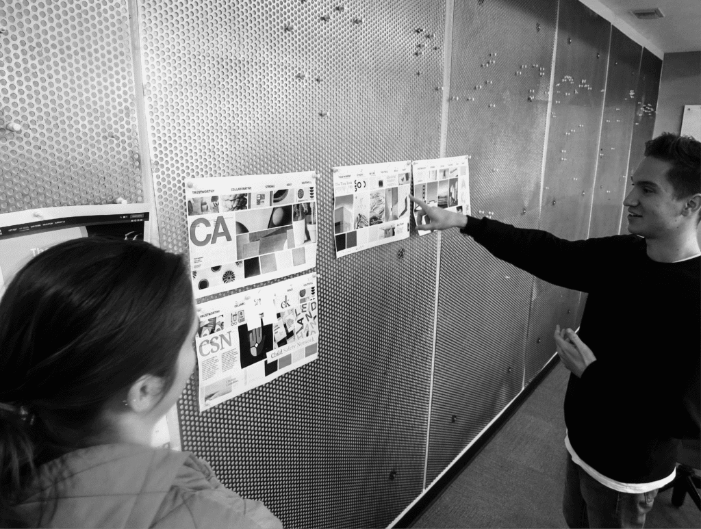 2 RKS Employee looking at different displays on wall of Child Safety Network branding