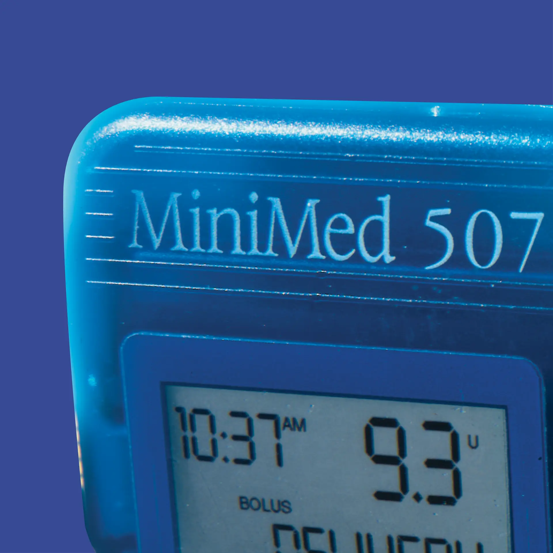 Close-up of a blue MiniMed 507 medical device screen displaying the time 10:37 AM and a dosage of 9.3 units, against a solid blue background, showcasing innovation from a leading Medical Device Design Firm.