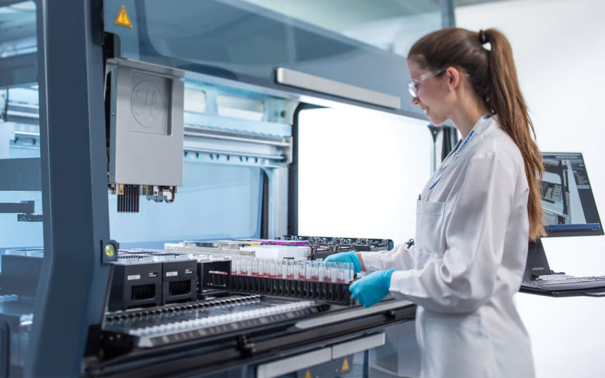 Technician loading samples into Hamilton Vantage, designed by RKS Design to optimize liquid handling for streamlined lab workflows.