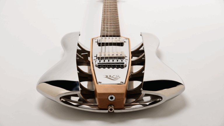 Close-up of RKS electric guitar with exposed sculptural body and chrome detailing
