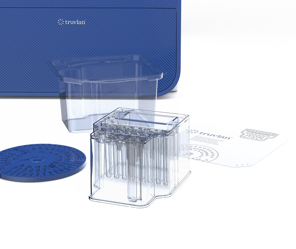 Clear diagnostic cartridge components laid out in front of Truvian device, showcasing modular tube system and blue branding