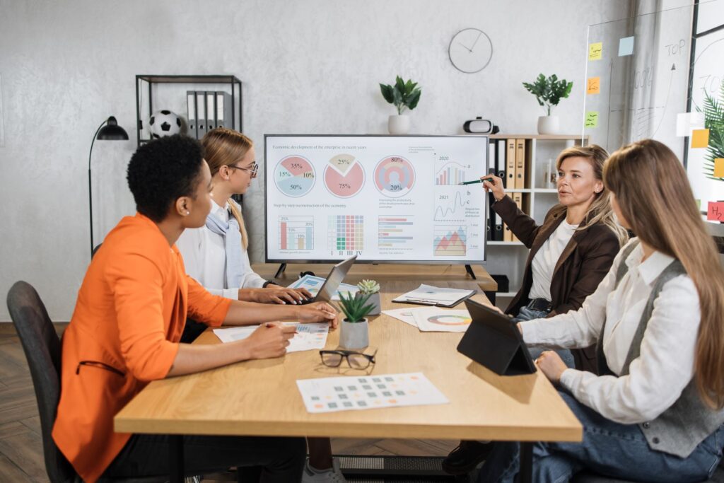 Team gathered around a conference table presenting stakeholder pitch materials