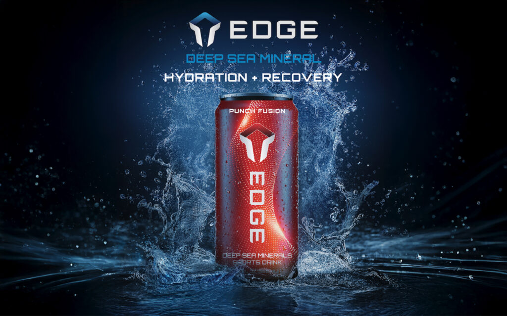 A red can of EDGE Deep Sea Minerals sports drink, flavor Punch Fusion, stands upright with water splashing around it. The background is dark with blue highlights. Text above reads: EDGE - Deep Sea Mineral - Hydration + Recovery.
