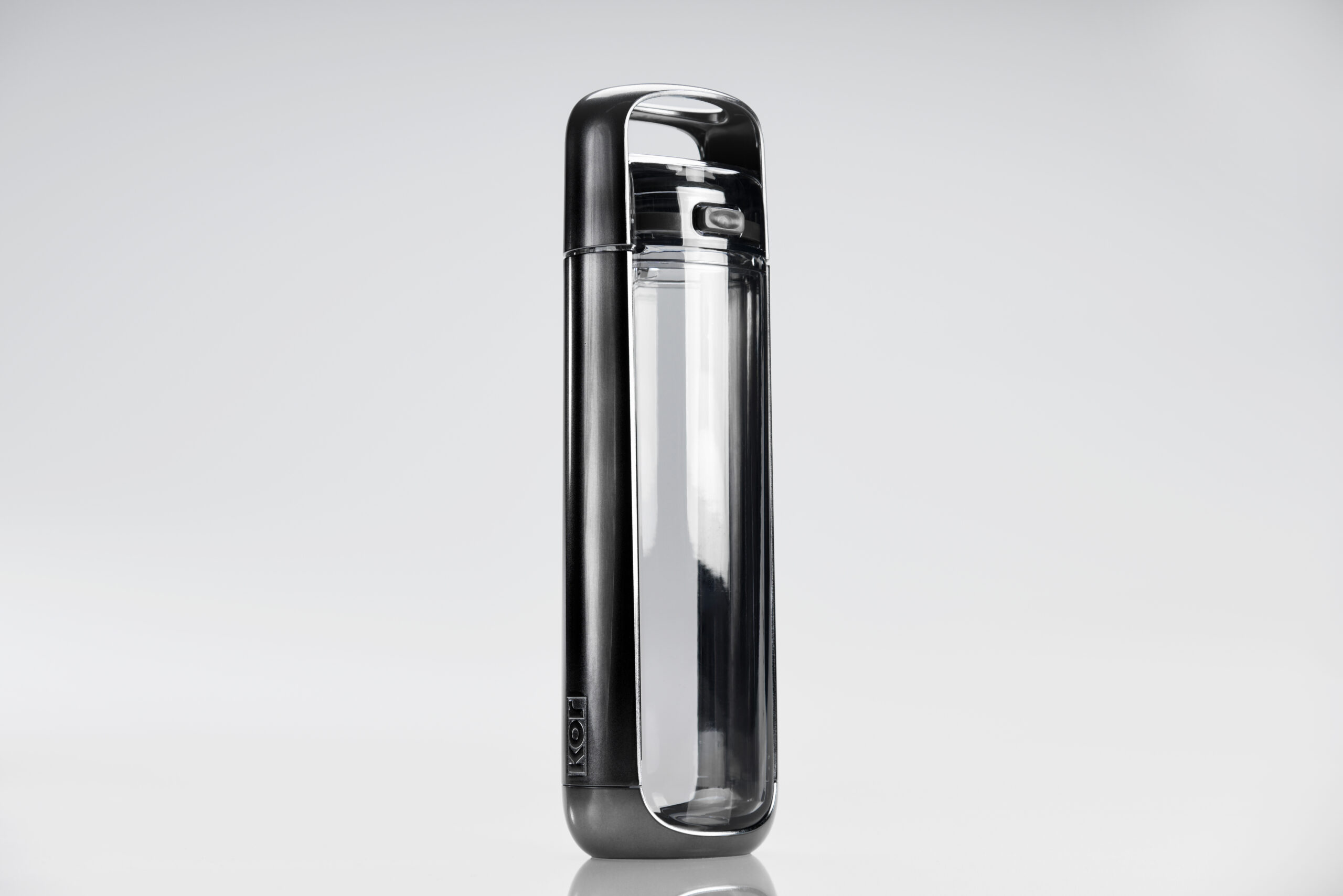 A sleek, modern water bottle with a metallic black frame and a transparent body, standing upright on a reflective white surface.